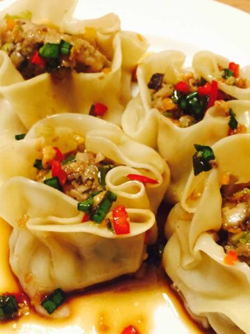 Veal steamed dumplings or dim sum on a white plate