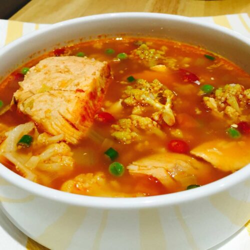 Organic veggies and fish soup, in a white bowl